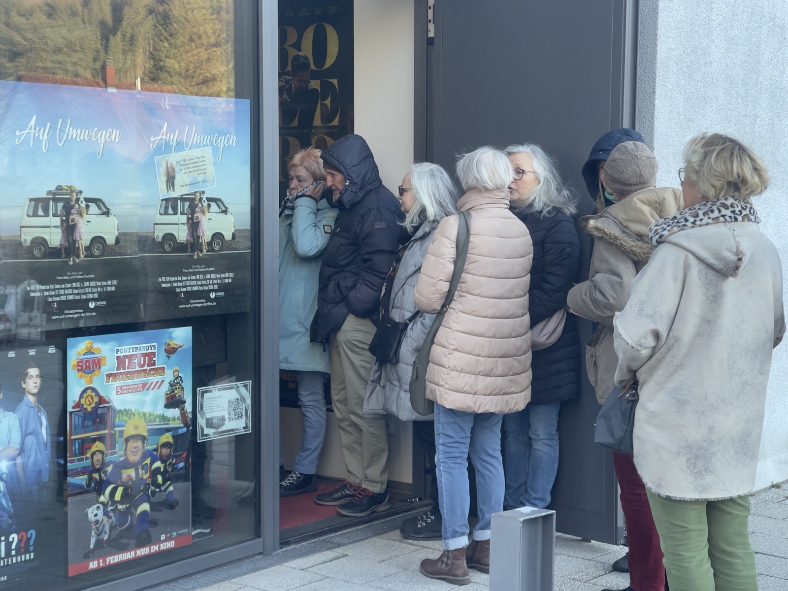 Publikum wartet vor dem Kino